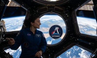 Astronauta Jessica Meir na Estação Espacial Internacional com patch Artemis II, simbolizando o caminho para o retorno à Lua.