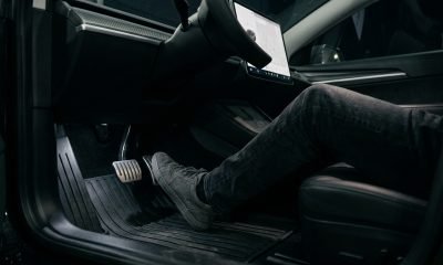 Pé de motorista sobre o pedal do acelerador de um Tesla, ilustrando a tecnologia de condução com um pedal da Tesla e a discussão sobre aceleração inesperada.