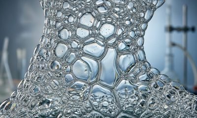 Uma imagem de close-up mostrando a dinâmica da descoberta espuma, com bolhas se rearranjando e líquido drenando através de novos caminhos em um ambiente de labo