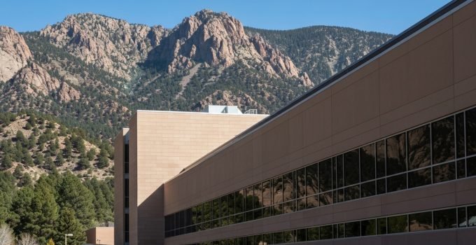 Fachada do Centro Nacional de Pesquisa Atmosférica (NCAR) com montanhas ao fundo.